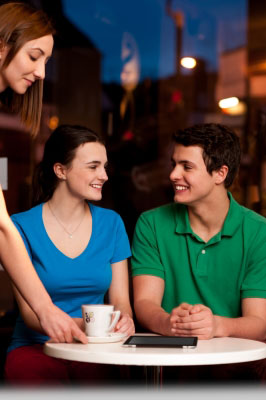 Couple Enjoying Coffee In Cafe by stockimages